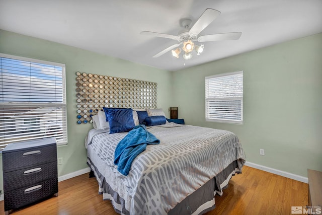 bedroom with a ceiling fan, baseboards, and wood finished floors