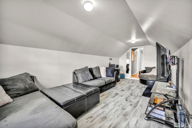 living area with lofted ceiling, light wood finished floors, and baseboards