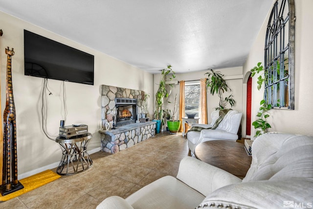 tiled living room featuring a fireplace and baseboards