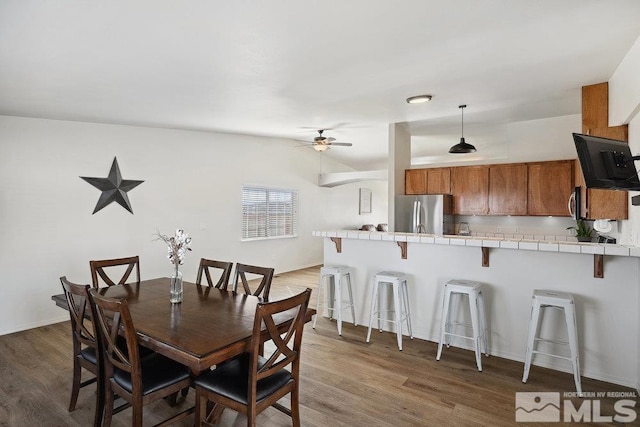 dining area featuring dark wood-style floors, ceiling fan, and baseboards