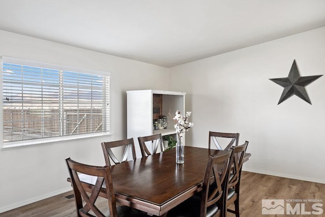 dining room with baseboards and wood finished floors