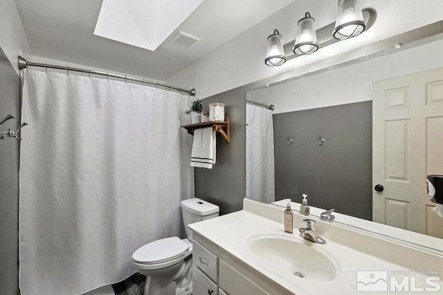 full bathroom with a skylight, visible vents, vanity, and toilet