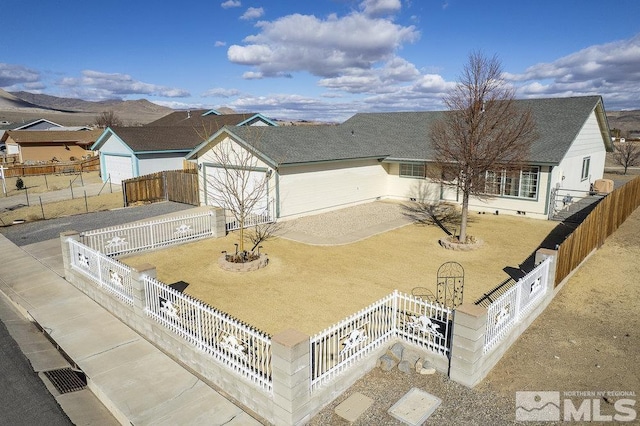 view of front facade with driveway, a shingled roof, a patio, and fence private yard