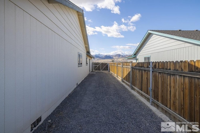 view of property exterior with fence and a mountain view