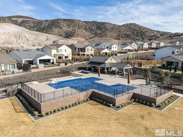 view of swimming pool with a residential view, a mountain view, a patio, and fence