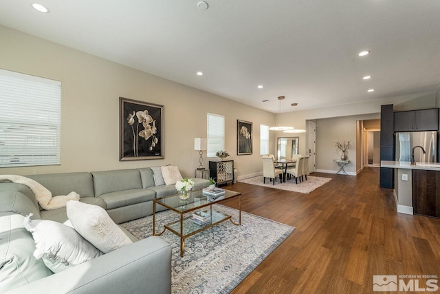 living room with dark wood-type flooring, recessed lighting, and a wealth of natural light