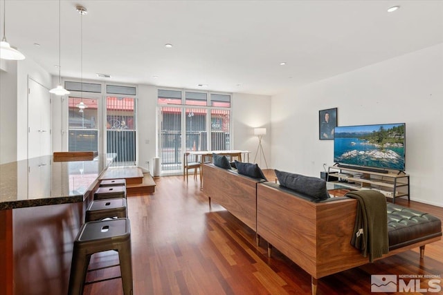 living room with recessed lighting, floor to ceiling windows, and wood finished floors