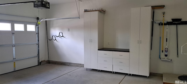 garage featuring a garage door opener and baseboards