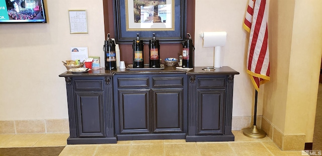 bar with a dry bar and tile patterned floors