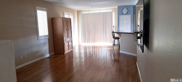 interior space featuring dark wood-type flooring and baseboards