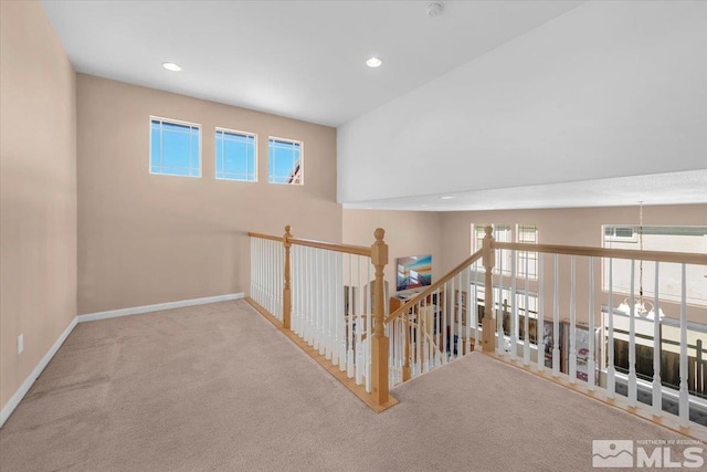 hallway featuring an upstairs landing, carpet, baseboards, and recessed lighting