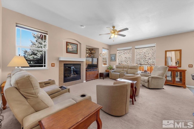 living room featuring ceiling fan, a fireplace, and light colored carpet