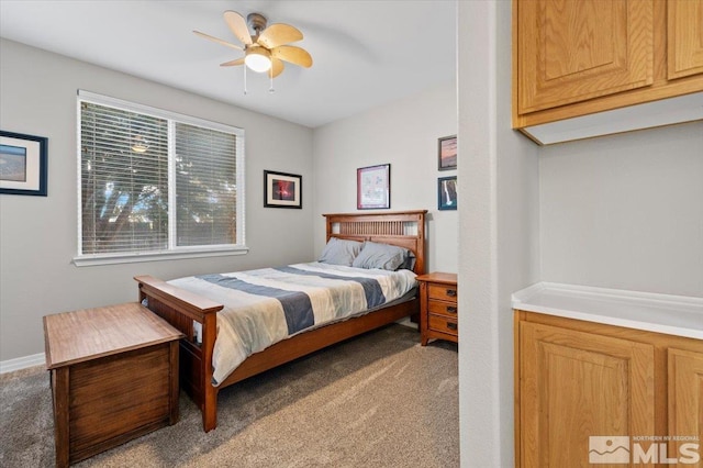 carpeted bedroom with ceiling fan and baseboards