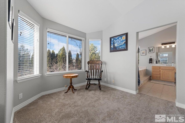 sitting room with carpet floors, a healthy amount of sunlight, vaulted ceiling, and tile patterned floors