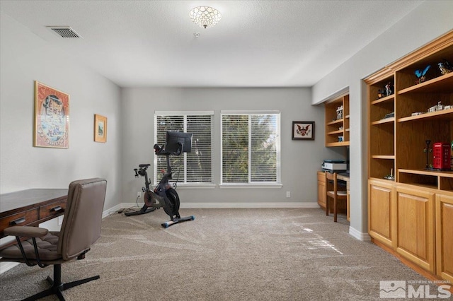 office space with baseboards, visible vents, a textured ceiling, and light colored carpet