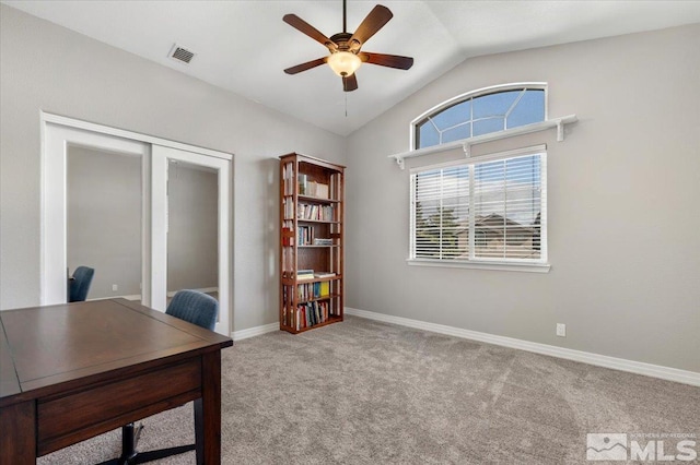 carpeted home office with visible vents, vaulted ceiling, baseboards, and ceiling fan