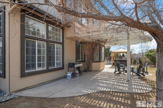 view of patio with fence, grilling area, and a gazebo