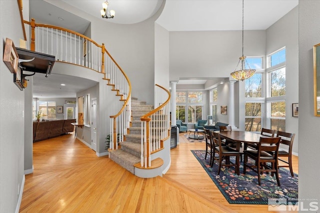 interior space with a high ceiling, stairway, wood finished floors, and baseboards