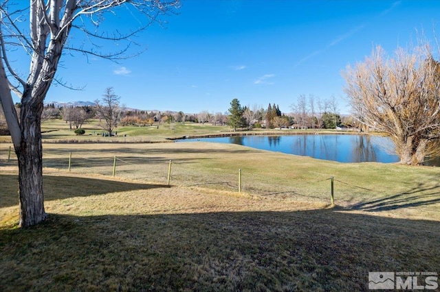 view of yard with a water view and fence