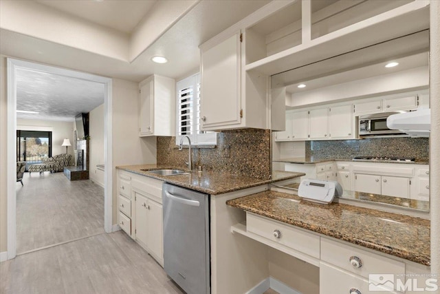 kitchen with white cabinetry, dark stone countertops, appliances with stainless steel finishes, and a sink