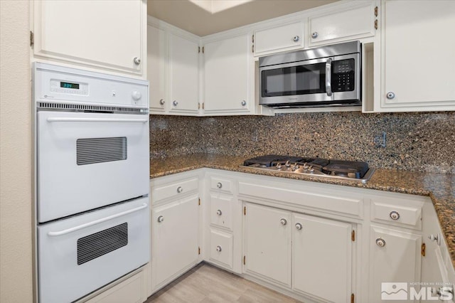 kitchen featuring appliances with stainless steel finishes, white cabinetry, and decorative backsplash