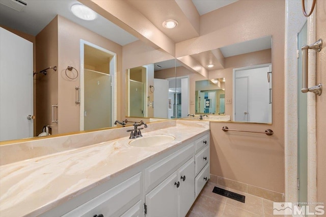 full bath with a stall shower, vanity, visible vents, and tile patterned floors