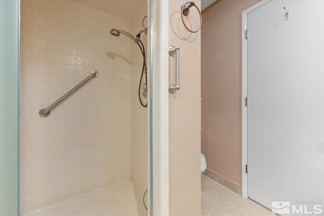 bathroom with a shower, toilet, and tile patterned floors