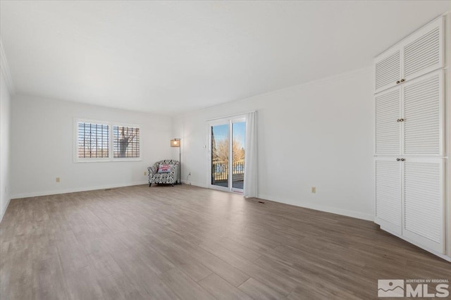 unfurnished bedroom featuring access to outside, crown molding, baseboards, and wood finished floors