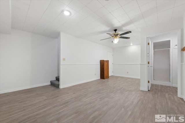 interior space with stairway, ceiling fan, baseboards, and wood finished floors