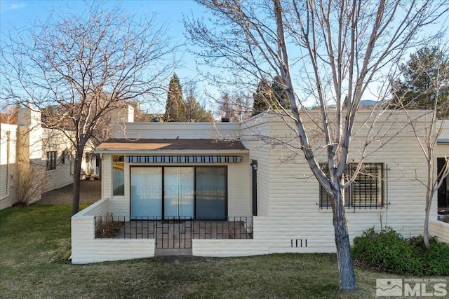 back of property featuring a lawn