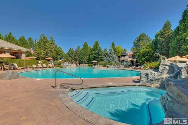 community pool with a patio and fence