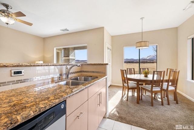 kitchen with decorative light fixtures, visible vents, stone countertops, a sink, and dishwasher