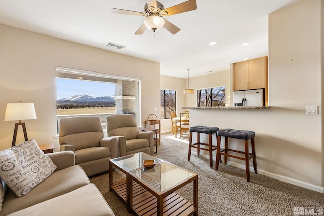 living room with dark colored carpet, recessed lighting, visible vents, a mountain view, and baseboards