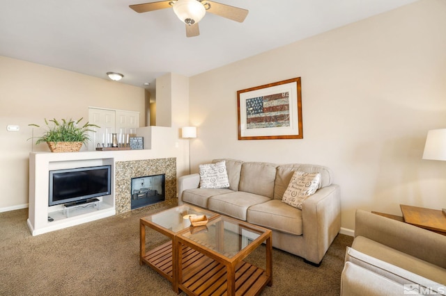 carpeted living area with a ceiling fan, a tile fireplace, and baseboards