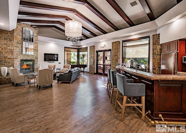 interior space featuring visible vents, paneled refrigerator, a fireplace, and wood finished floors