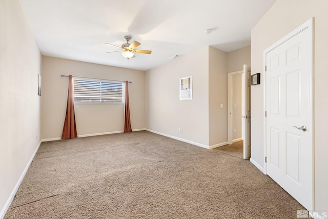 empty room with carpet floors, ceiling fan, and baseboards