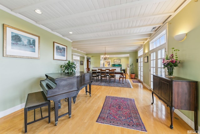 living area with baseboards, beamed ceiling, french doors, light wood-type flooring, and a notable chandelier