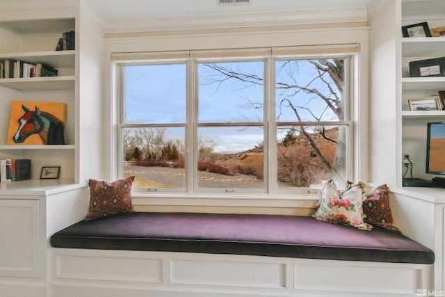 interior space with built in shelves and crown molding