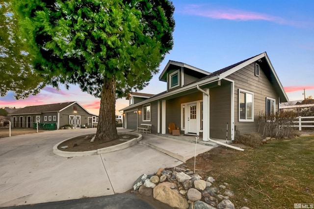 view of front of home with a garage, driveway, and fence