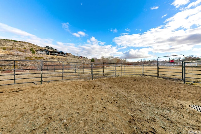 view of yard featuring a rural view, an enclosed area, and fence