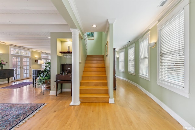 stairs featuring decorative columns, baseboards, wood finished floors, french doors, and beam ceiling