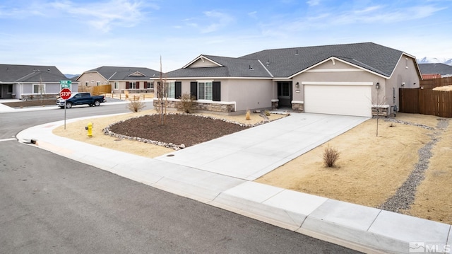 ranch-style home with driveway, a shingled roof, stone siding, fence, and stucco siding