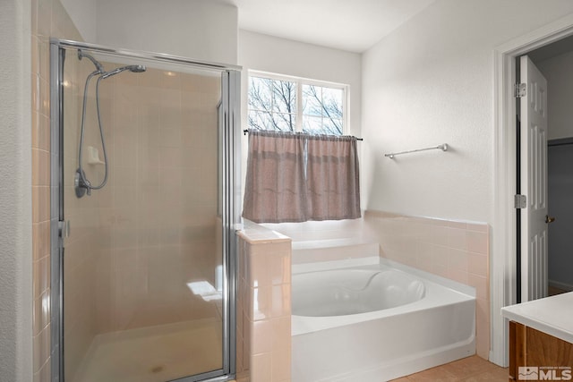 full bath with a stall shower, vanity, and a bath