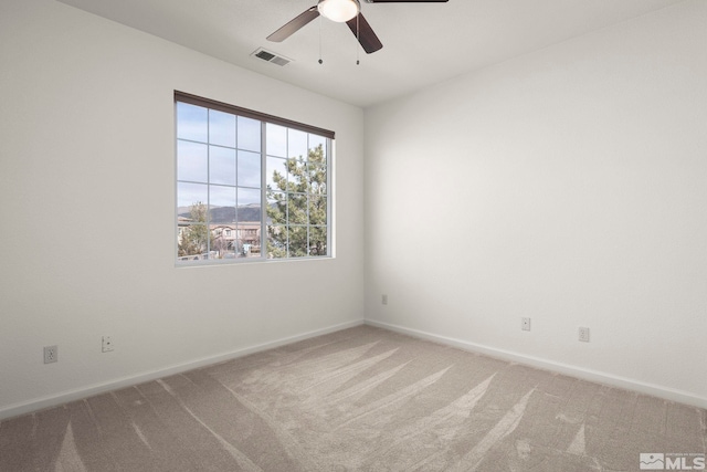 empty room featuring light carpet, baseboards, visible vents, and a ceiling fan