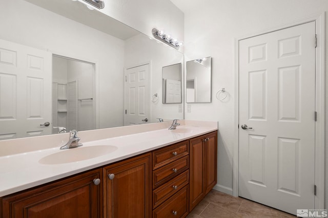 full bath with double vanity, a sink, and tile patterned floors