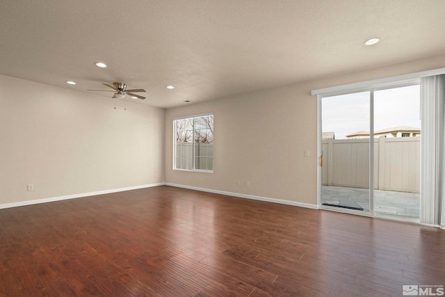 empty room featuring dark wood-type flooring, recessed lighting, a ceiling fan, and baseboards