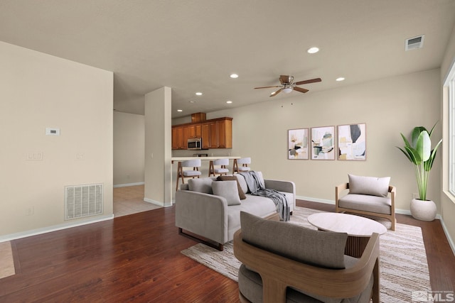 living room with recessed lighting, visible vents, and wood finished floors