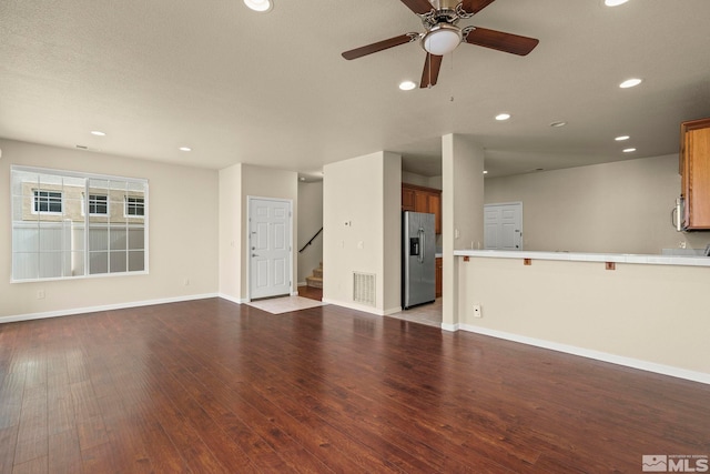 unfurnished living room with recessed lighting, visible vents, baseboards, stairway, and wood-type flooring