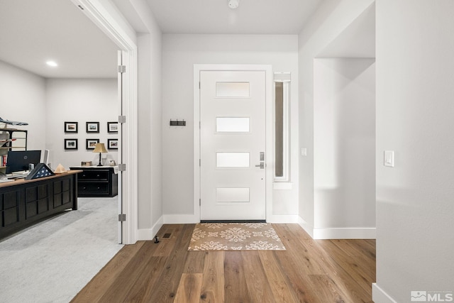 entryway featuring baseboards and wood finished floors