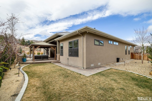 rear view of house featuring stucco siding, a gazebo, crawl space, a patio area, and fence